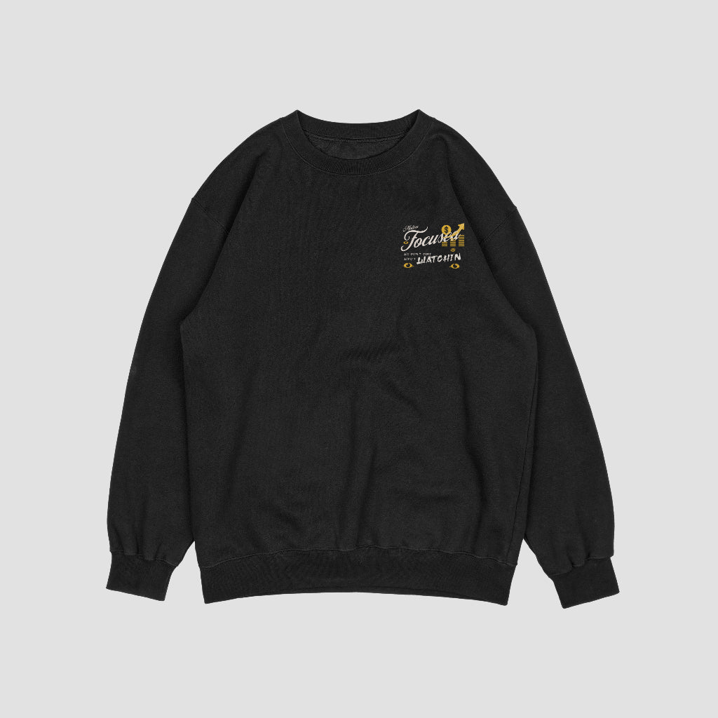 "Black sweatshirt featuring a bold design by Motion Focused, with a crowned character sitting on a throne, surrounded by gold accents, dollar signs, and watchful eyes. Includes the empowering slogan 'We Don't Care Who's Watchin' in stylish lettering."